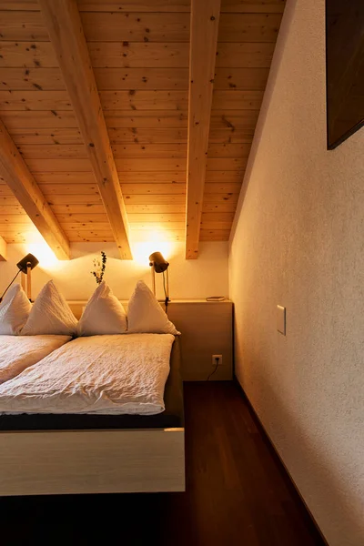 Rahat bir yatak odası ve manzaralı bir dağ manzaralı bir İsviçre otel odası atmosferi. İçerisi konforu, konukseverliği ve rahatlatıcı bir alp konaklamasını yansıtıyor. Seyahat konaklama, turizm, rahatlama ve Avrupa 'ya uygun konseptler