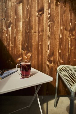 İsviçre yazında dağ manzaralı sandalyeler, çay, kahve ve kitapların yer aldığı bir otel balkonu ve göl manzarası. Sahne, rahat bir dağlık yaşam tarzı, huzurlu bir atmosfer ve rahat bir seyahat deneyimi yakalıyor. Konseptler için uygun