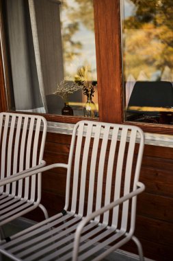 Kamera, kahve, çay, not defteri ve masanın üzerine yerleştirilmiş bir kitap gibi seyahat gerekliliklerinin yer aldığı bir İsviçre otelinin iç atmosferi. Sahne konfor, ilham ve rahat bir seyahat tarzı sunar. Turizm kavramları için uygun