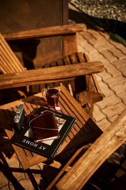 İsviçre yazında dağ manzaralı sandalyeler, çay, kahve ve kitapların yer aldığı bir otel balkonu ve göl manzarası. Sahne, rahat bir dağlık yaşam tarzı, huzurlu bir atmosfer ve rahat bir seyahat deneyimi yakalıyor. Konseptler için uygun