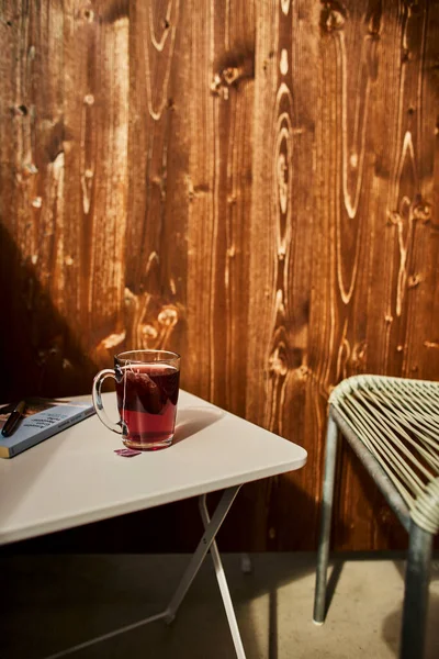 İsviçre yazında dağ manzaralı sandalyeler, çay, kahve ve kitapların yer aldığı bir otel balkonu ve göl manzarası. Sahne, rahat bir dağlık yaşam tarzı, huzurlu bir atmosfer ve rahat bir seyahat deneyimi yakalıyor. Konseptler için uygun