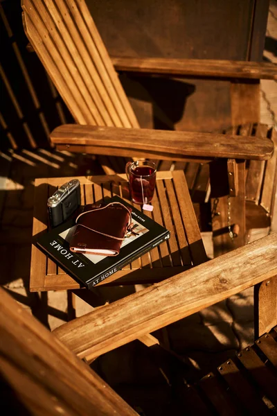 İsviçre yazında dağ manzaralı sandalyeler, çay, kahve ve kitapların yer aldığı bir otel balkonu ve göl manzarası. Sahne, rahat bir dağlık yaşam tarzı, huzurlu bir atmosfer ve rahat bir seyahat deneyimi yakalıyor. Konseptler için uygun