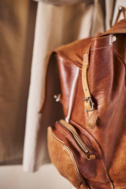 Bir otel odasındaki askıda asılı duran bir ceket ve bir çanta. Sahne, konaklama yerlerindeki organizasyon, konukseverlik ve detaylara dikkat etmeyi yansıtıyor. Seyahat, iç tasarım, otel yaşam tarzı ve misafir konforu için uygundur..