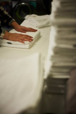 Çamaşırhanede yeni yıkanmış beyaz havluları katlayan bir otel çalışanı. Olay yeri temizliği, konukseverliği ve organize otel operasyonlarını içeriyor. Seyahat, turizm, otel servisi, ev idaresi ve Avrupa 'da barınma kavramları için elverişli