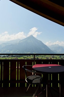 Rahat bir yatak odası ve manzaralı bir dağ manzaralı bir İsviçre otel odası atmosferi. İçerisi konforu, konukseverliği ve rahatlatıcı bir alp konaklamasını yansıtıyor. Seyahat konaklama, turizm, rahatlama ve Avrupa 'ya uygun konseptler