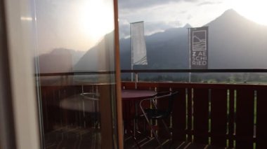 İsviçre 'deki bir otel odasından Niesen Dağı' nın açık bir yaz manzarası. Sahne, rahat bir konaklama ve doğal güzellik arasındaki bağlantıyı vurgulayan açık hava, dağ manzarası ve huzurlu bir atmosfere sahiptir. Uygun.