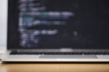 Modern ofis ortamında programlama için kullanılan bir dizüstü bilgisayar. Sahne kodlamayı, yazılım geliştirmeyi, üretkenliği ve çağdaş çalışma alanı kurulumunu ön plana çıkarıyor. Teknoloji, bilişim işi, uzaktan çalışma, ofis hayatı ve dijital için uygun