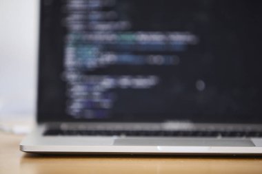 Modern ofis ortamında programlama için kullanılan bir dizüstü bilgisayar. Sahne kodlamayı, yazılım geliştirmeyi, üretkenliği ve çağdaş çalışma alanı kurulumunu ön plana çıkarıyor. Teknoloji, bilişim işi, uzaktan çalışma, ofis hayatı ve dijital için uygun