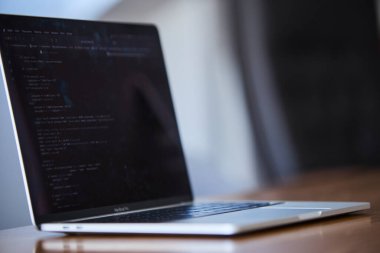 Modern ofis ortamında programlama için kullanılan bir dizüstü bilgisayar. Sahne kodlamayı, yazılım geliştirmeyi, üretkenliği ve çağdaş çalışma alanı kurulumunu ön plana çıkarıyor. Teknoloji, bilişim işi, uzaktan çalışma, ofis hayatı ve dijital için uygun