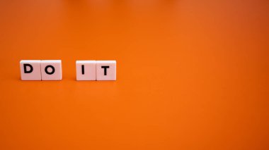Canlı Turuncu Arkaplan Üzerine Beyaz Harf Döşemeleri ile Yazılan Motivasyonel İfade