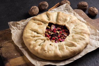 Elmalı, böğürtlenli ve cevizli ev yapımı galet turta. Eski ahşap tahtada taze ahududu ile süslenmiş.