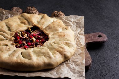 Elmalı, böğürtlenli ve fındıklı ev yapımı galette turtası. Kırsal arka planda taze inek çileğiyle süslenmiş.