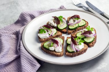 Kızarmış ekmekli kanepeler, ayçiçeği ve keten tohumları, feta peyniri, salatalık ve soğan.