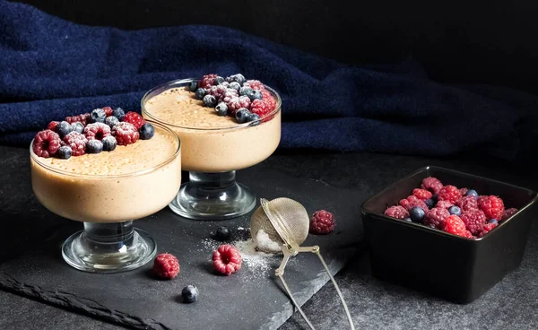 Ryazhenka (fermented baked milk) mousse in glass bowls decorated with fresh berries