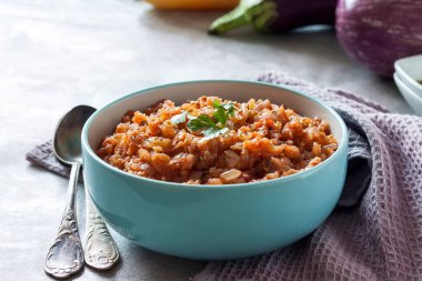 Mavi kasede patlıcan havyarı ve arka planda taze sebzeler..