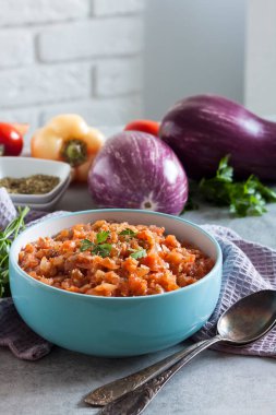 Mavi kasede patlıcan havyarı ve arka planda taze sebzeler..