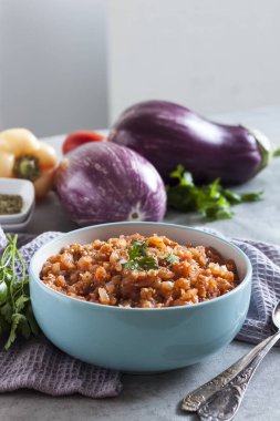 Mavi kasede patlıcan havyarı ve arka planda taze sebzeler..