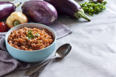 Mavi kasede patlıcan havyarı ve arka planda taze sebzeler. Boşluğu kopyala