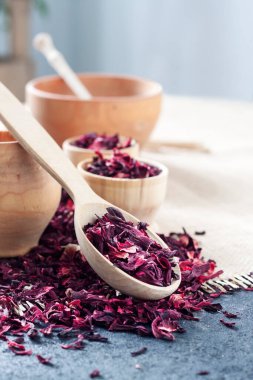 Tahta kaşıkta kuru amber çayı ve saman hasırlı küçük bardaklar.