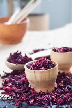 Tahta kaşıkta kuru amber çayı ve saman hasırlı küçük bardaklar.