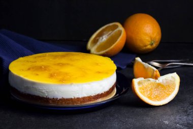 Kremalı turuncu pasta ve koyu arkaplanda turuncu jöle.