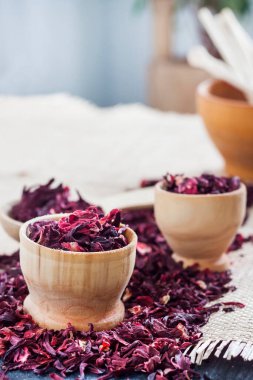 Tahta kaşıkta kuru amber çayı ve saman hasırlı küçük bardaklar.