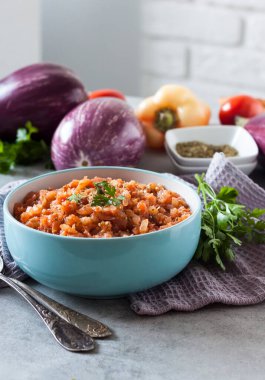 Mavi kasede patlıcan havyarı ve arka planda taze sebzeler..