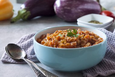 Mavi kasede patlıcan havyarı ve arka planda taze sebzeler..