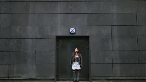 Девушка ждет кого-то возле железной двери . — стоковое видео