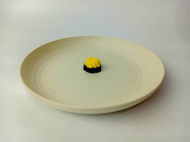 Üstü sarı çikolatalı, tabakta servis edilen, beyaz arka planda izole edilmiş..