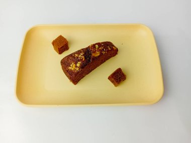 Güzel bir muz keki, peynirli, kare bir tabakta servis ediliyor, beyaz bir arka planda izole edilmiş..