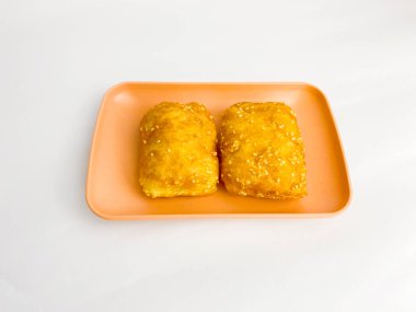 Roti Goreng 'veya Kızarmış Ekmek küp ya da blok halinde, açık kahverengi bir dış deri ve susam tohumlarıyla serpiştirilmiş, içi tüylüdür. Tabakta servis edilir, beyaz arkaplanda izole edilir..