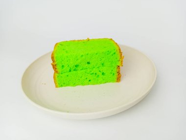 Matcha chiffon slice cake cut in half served on a round plate, isolated on white background. Delicious cake.