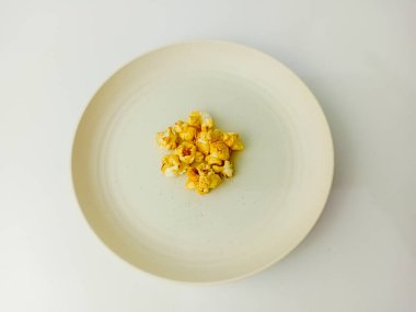 Yuvarlak tabakta tatlı karamelli patlamış mısır, beyaz arka planda izole..