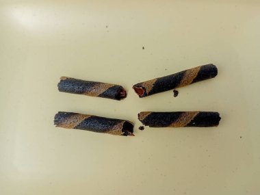 Astor çikolatası ikiye bölünmüş, kare bir tabakta servis edilmiş, izole edilmiş beyaz arka plan..