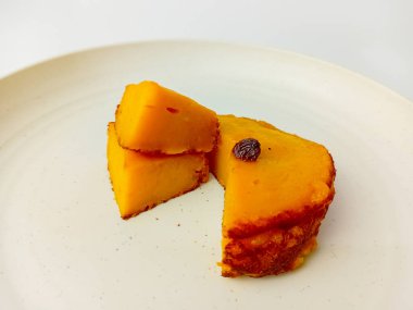 Kue Lumpur ya da Mud keki parçalara ayrılmış. Ana malzemeler olarak hindistan cevizi sütü, patates, buğday unu ve yumurtadan yapılan aperatif yuvarlak bir tabakta servis edilir..