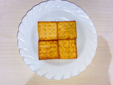 Beyaz tabaktaki şekerli krakerler ya da şekerli bisküviler, beyaz arka planda izole edilmiş..