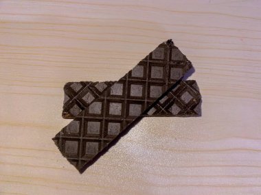 Kurabiye kremalı ve kahveli waffle, ahşap desenli arka planda izole edilmiş. Lezzetli çerez.