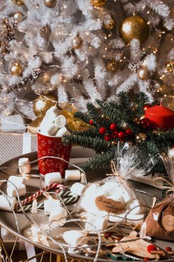 Hediyeler ve ikramlar masada hazır. Noel ağacı ve hediyeler