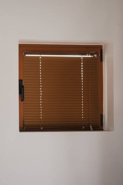 Kahverengi plastik pencere, içinde kahverengi panjurlar, beyaz boyanmış duvarlar modern ev tasarımı ve temiz minimalist mimari..