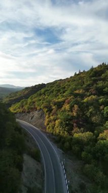 Sonbaharda Georgia 'da dolambaçlı dağ yolu. Kafkasya ormanı ve Tiflis yakınlarındaki manzaralı yamaçlarda yapılan hava aracı yolculuğu videosu..