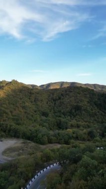 Sonbaharda Georgia 'da dolambaçlı dağ yolu. Kafkasya ormanı ve Tiflis yakınlarındaki manzaralı yamaçlarda yapılan hava aracı yolculuğu videosu..