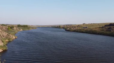 Ukrayna bozkırlarında eski granit kayaları ve yemyeşil nehir kıyıları olan pitoresk bir gölet. Mariupol, Donetsk bölgesi yakınlarındaki Yekaterinovka köyünün doğal güzelliği