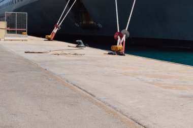 Rıhtımdaki iskeleye demirleme halatlarını kullanarak bir gemiyi demirlemek. İyi kalite fotoğraf.