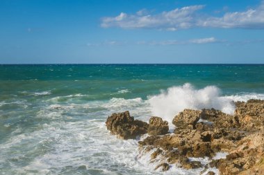 Rüzgârlı ama güneşli bir havada Akdeniz kıyılarda dalgalar koparken kıyı melteminin ve yaz havasının ruhunu yakalıyor...