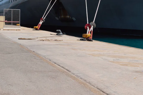 Rıhtımdaki iskeleye demirleme halatlarını kullanarak bir gemiyi demirlemek. İyi kalite fotoğraf.