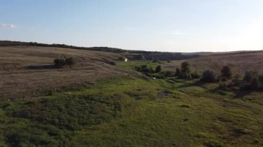 Doğu Ukrayna 'nın kırsal kesimindeki dolambaçlı bir deresi olan yemyeşil bir vadiye uzanan kayalık bir vadinin yaz manzarası. Yüksek kaliteli FullHD görüntüler