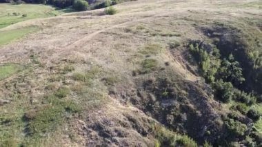 Doğu Ukrayna 'nın kırsal kesimindeki dolambaçlı bir deresi olan yemyeşil bir vadiye uzanan kayalık bir vadinin yaz manzarası. Yüksek kaliteli FullHD görüntüler