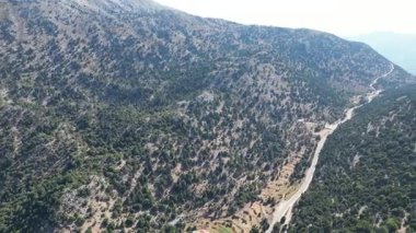 İnsansız hava aracı manzarası: Girit 'in Omalos köyü yakınlarındaki yüksek açılı yaz manzarası. Görüntü, uçsuz bucaksız, bozulmamış doğayı, temiz havayı ve uzak bölgenin dramatik yükselişini vurguluyor.