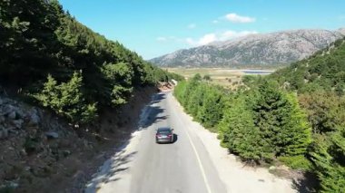 Girit 'teki ücra bir dağ ormanından geçen tek bir arabanın insansız hava aracı görüntüsünde yalnızdım. Özgürlük, tecrit keşfi ve uzun bir yolculuğun yalnızlığını taşır.